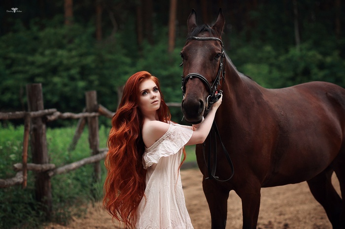 Redhead woman with long wavy hair and a horse