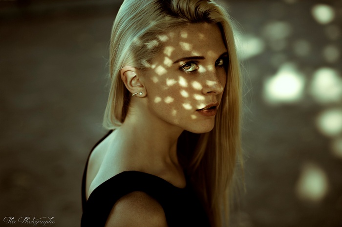 Portrait of a blonde woman with dappled light on her face
