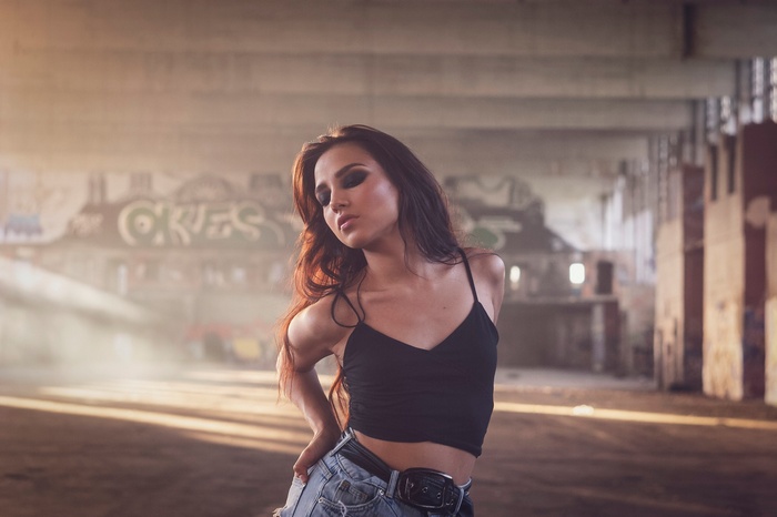 Woman in crop top and jean shorts in abandoned building
