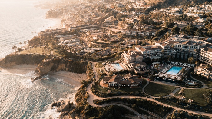 Aerial view of a coastal resort with swimming pools and ocean