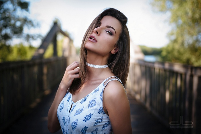 Woman wearing a choker and dress on a bridge