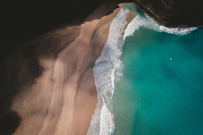 Aerial view of a beach with turquoise water and waves