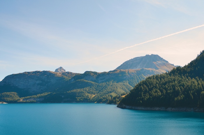 Turquoise lake and forested mountains under a clear sky