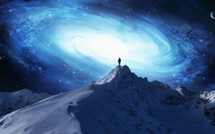 Man on mountain peak looking at galaxy