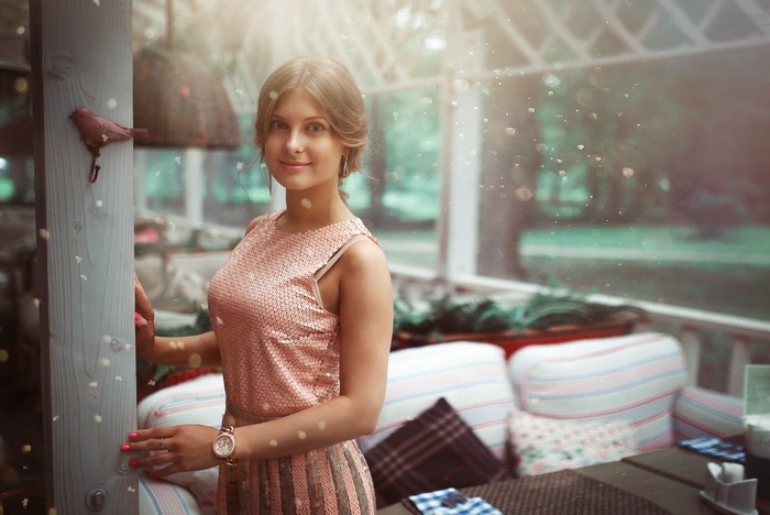 Woman in sequined dress standing near a wooden post