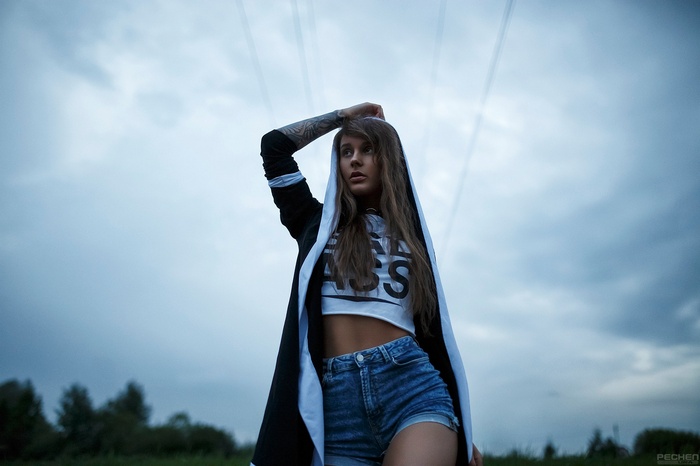 Woman with tattoo wearing jean shorts and hoodie outdoors