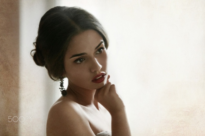 Woman with hand on face and red lipstick