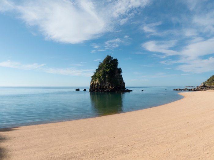 Rock formation in the ocean near a sandy beach