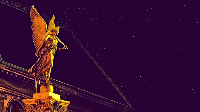 Golden angel statue at night with stars