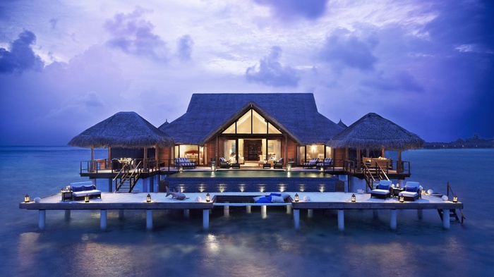 Overwater bungalows with swimming pool at dusk