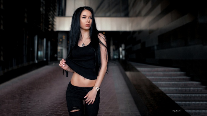 Woman in black tank top and torn jeans