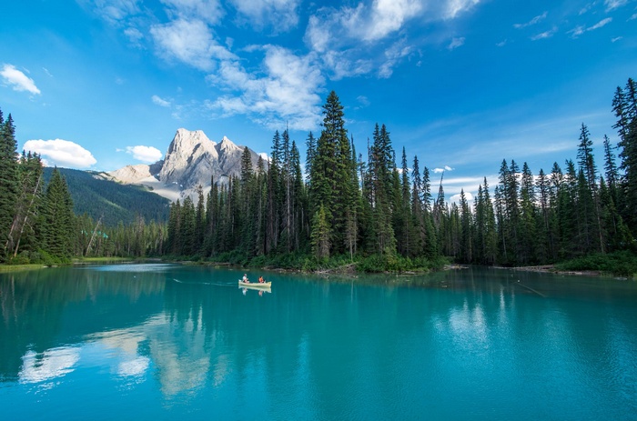 Canoe on a turquoise lake with mountains and trees