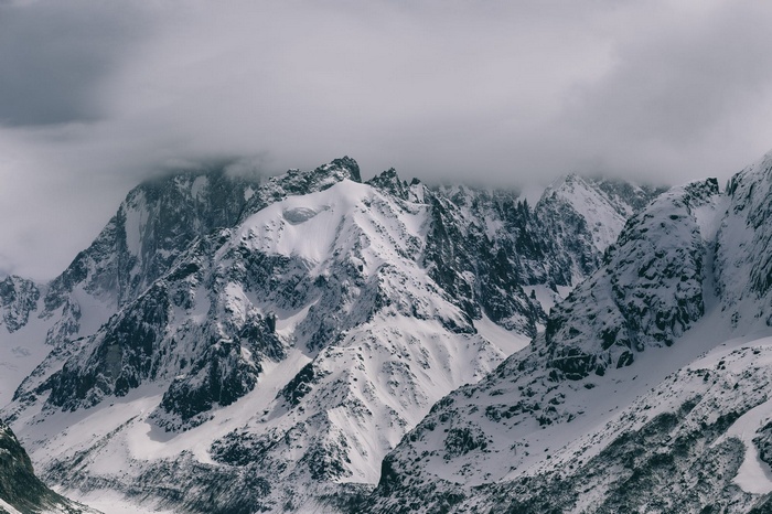 Snow-covered mountains under clouds in winter