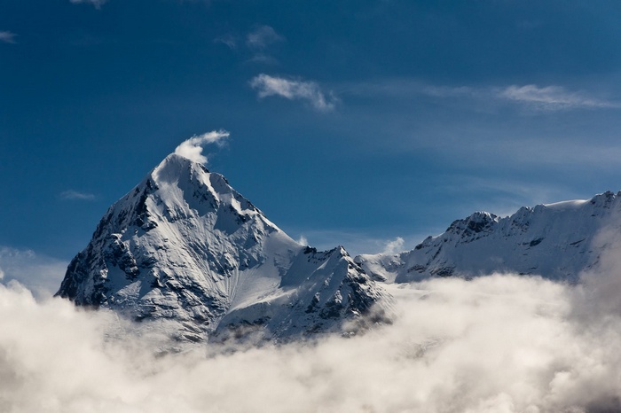 Snowy mountain peak above clouds in Switzerland