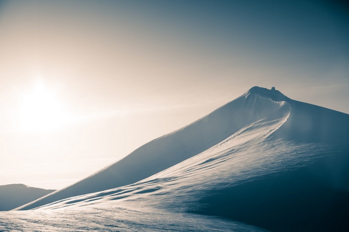Snowy mountain peak under a bright sun