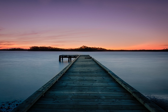 Wooden pier on a calm lake at sunset