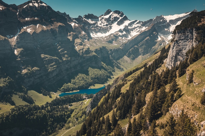Snow-capped mountains overlooking a blue lake and forest
