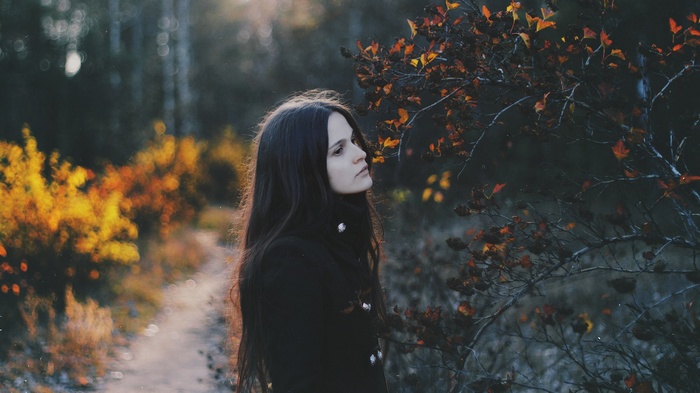 Natalia Drepina in a black coat outdoors in fall