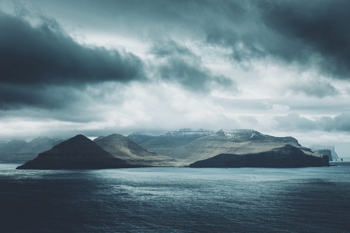 Stormy clouds over mountains and sea in Faroe Islands