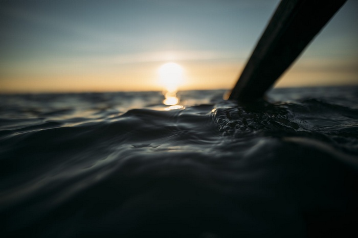 Oar in water at sunset