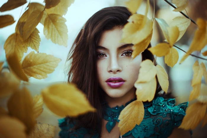 Woman with autumn leaves in portrait