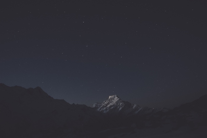 Snow-capped mountain under a starry night sky
