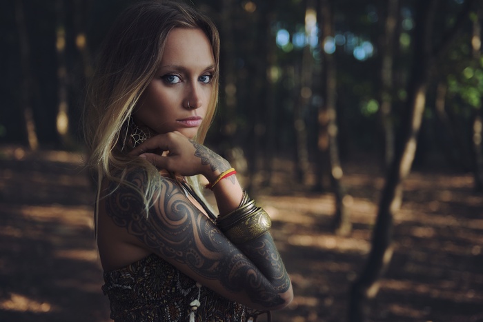Anastasia Vervueren with tattoos and bangles in forest