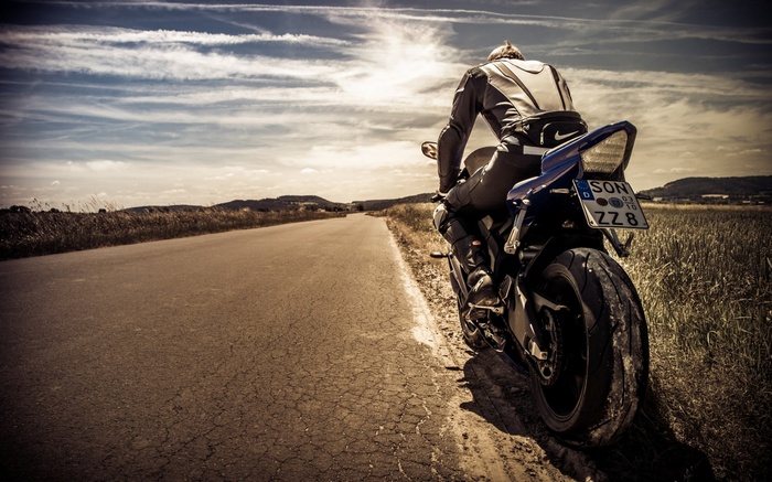 Motorcyclist on a road in a rural landscape