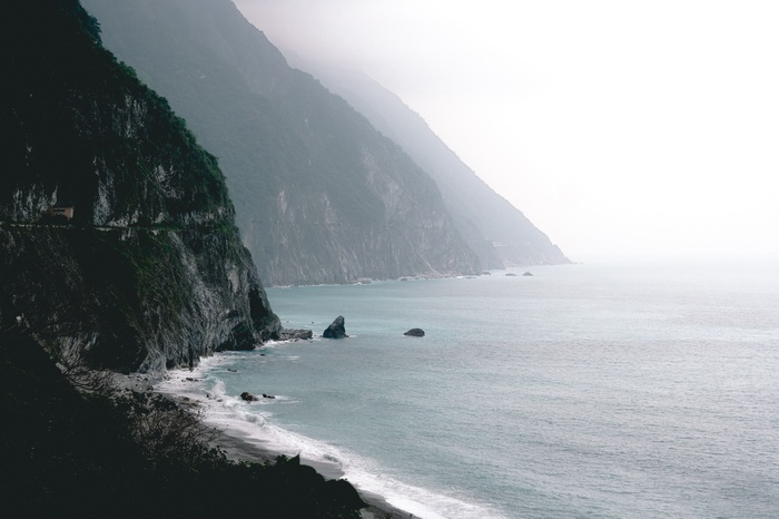 Coastal mountains meeting the sea on a foggy day