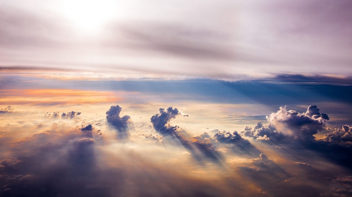 Aerial view of sun rays through clouds at sunset