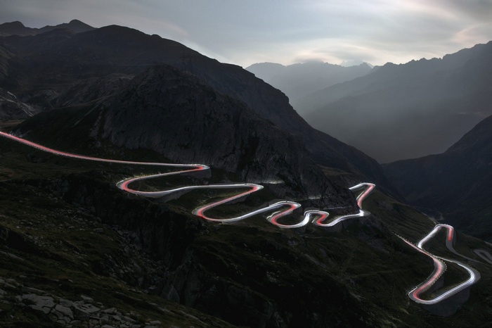 Mountain road with light trails at dusk