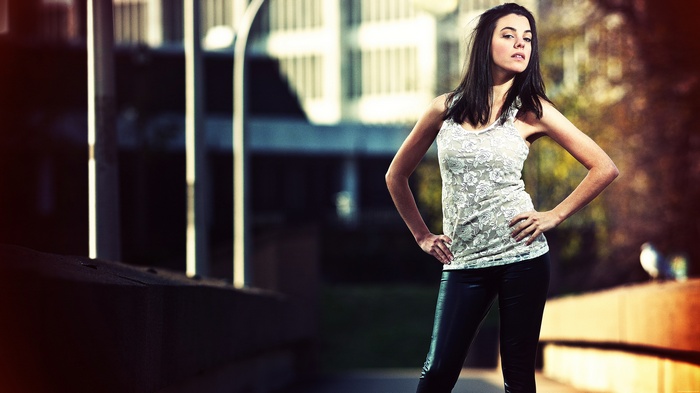 Woman in white lace top and black pants posing