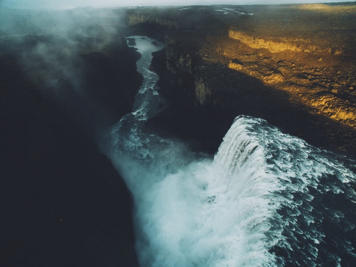 Waterfall cascading into a canyon with mist