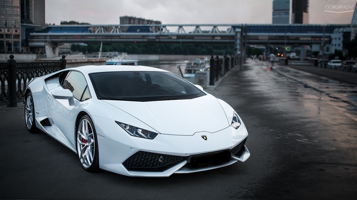 White Lamborghini Huracan parked by a river in a city