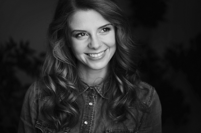 Monochrome portrait of a smiling woman in a denim shirt