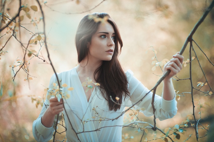 Woman in white dress among branches
