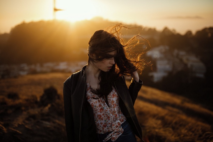 Woman in leather jacket at sunset