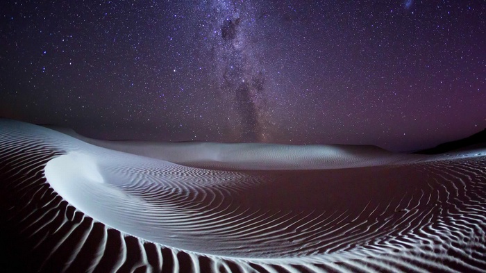 Milky Way over desert sand dunes at night