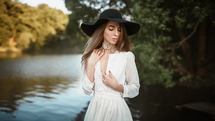 Woman in white dress and black hat by Anastasia Zakhvataeva