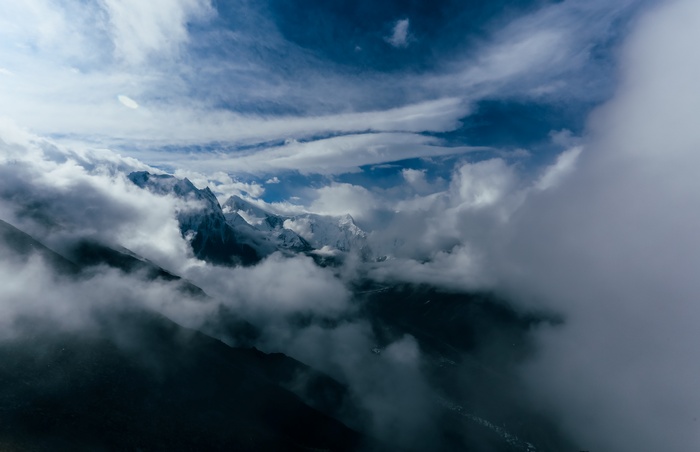 Snow-capped mountains shrouded in mist and clouds