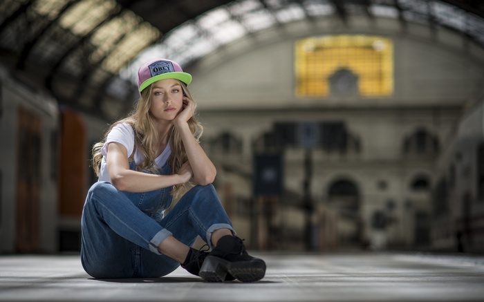 white shirt, blonde, women, train station, overalls, jeans, baseball caps, sitting, looking at viewer, flap trousers