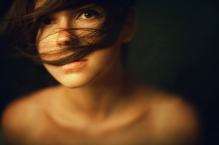Woman with hair covering face, bare shoulders
