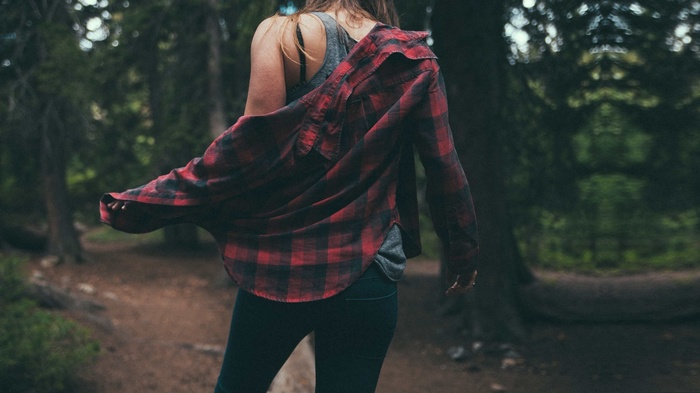 Woman wearing a plaid shirt in a forest