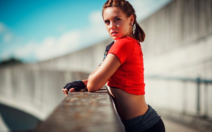 Woman in red top and gloves leaning on railing