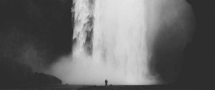 Monochrome waterfall with a lone person standing