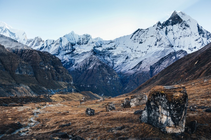 Snow-capped mountains and a valley with rocks