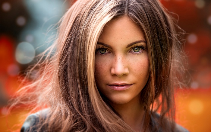 Close-up portrait of a young woman with freckles