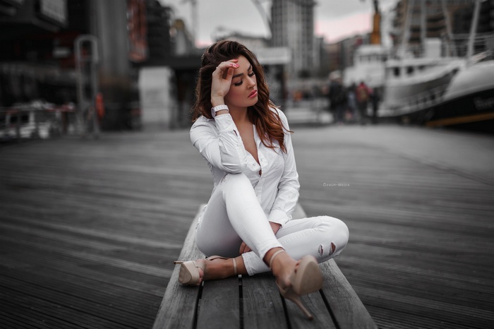 Woman in white clothing sitting on a bench