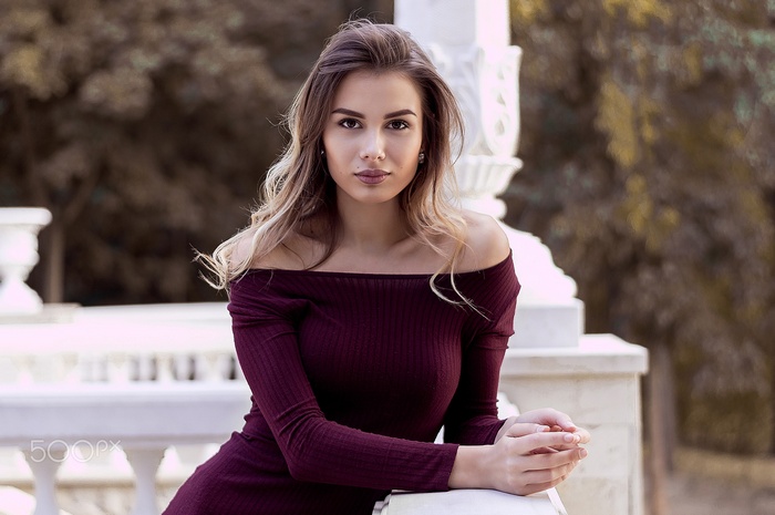 Woman in off-the-shoulder dress looking at viewer