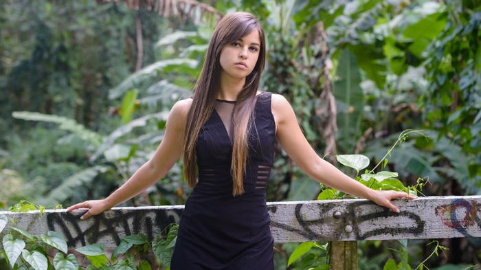 Woman in black dress posing outdoors